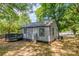 Backyard featuring a single-story home with gray siding, trees, and manicured lawn at 111 Quinn Ave, Gastonia, NC 28054