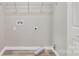 Bright laundry room features gray walls, wood-look flooring, shelving, and washer/dryer hookups at 111 Quinn Ave, Gastonia, NC 28054