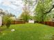 Backyard featuring grassy lawn, wood fence, storage shed, and green trees at 1113 Gregory Ln, Statesville, NC 28677