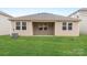 Backyard of the property showing green grass, siding, windows, door, and air conditioner condenser at 1125 Hallman Branch Ln, Lincolnton, NC 28092
