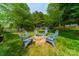 Backyard featuring a stone fire pit surrounded by comfortable Adirondack chairs for outdoor gatherings at 117 Middleton Pl, Mooresville, NC 28117