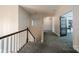 Upstairs hallway features plush carpeting, a stairway, and access to rooms via paneled french doors at 117 Middleton Pl, Mooresville, NC 28117
