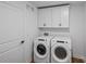 Well-lit laundry room features a front-load washer and dryer, overhead cabinets, and a door, offering convenience at 130 Fordham Ct # 18, Fort Mill, SC 29715
