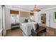 Elegant main bedroom with a woven light fixture, neutral tones, and a doorway that leads into the en suite bathroom at 130 Fordham Ct # 18, Fort Mill, SC 29715