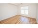 Minimalist bedroom featuring hardwood floors, a large window, and bright natural light at 14849 Santa Lucia Dr, Charlotte, NC 28277