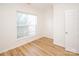 Bright bedroom featuring wood floors, large window, and white door at 14849 Santa Lucia Dr, Charlotte, NC 28277
