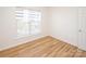 Well-lit bedroom with wood floors, large window, and white trim at 14849 Santa Lucia Dr, Charlotte, NC 28277
