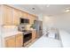 Well-lit kitchen with stainless steel appliances, light wood cabinets, and solid surface countertops at 14849 Santa Lucia Dr, Charlotte, NC 28277