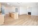 Open-concept living space with hardwood floors, kitchen island, and fireplace at 14849 Santa Lucia Dr, Charlotte, NC 28277