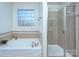 Bathroom features a soaking tub, separate glass shower, and natural light at 15236 Waterfront Dr, Huntersville, NC 28078
