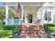 Inviting front porch with brick steps, black door and classic white pillars at 15236 Waterfront Dr, Huntersville, NC 28078