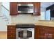Updated kitchen features stainless steel appliances, granite counters, wood cabinets, and tile backsplash at 15236 Waterfront Dr, Huntersville, NC 28078