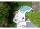 Aerial view of backyard featuring pool, hot tub, putting green, patio, and manicured lawn, surrounded by lush trees at 15603 Mccullers Ct, Charlotte, NC 28277