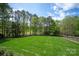 Large, well-maintained backyard with manicured lawn, surrounded by mature trees, offering a private outdoor space at 15603 Mccullers Ct, Charlotte, NC 28277