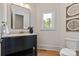 Well-lit bathroom with a dark vanity, gold fixtures, and modern decor at 15603 Mccullers Ct, Charlotte, NC 28277