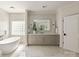 Bathroom featuring gray vanity, free standing tub and glass block window for natural light at 15603 Mccullers Ct, Charlotte, NC 28277
