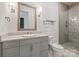 Bathroom featuring a single vanity, framed mirror, and glass shower with gray tiling at 15603 Mccullers Ct, Charlotte, NC 28277