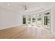Well-lit bedroom with hardwood floors, tray ceiling with fan, and big windows overlooking a golf course at 15603 Mccullers Ct, Charlotte, NC 28277