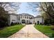 Elegant front elevation of home with circular driveway, manicured lawn, lush landscaping, and sophisticated architectural details at 15603 Mccullers Ct, Charlotte, NC 28277
