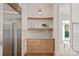 Kitchen detail with natural light, custom drawers and floating shelves and stainless steel refrigerator at 15603 Mccullers Ct, Charlotte, NC 28277