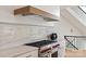 Close up of stainless steel gas range, marble backsplash and a modern vent hood at 15603 Mccullers Ct, Charlotte, NC 28277