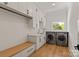 Functional laundry room with modern appliances, ample storage, and a wooden bench at 15603 Mccullers Ct, Charlotte, NC 28277