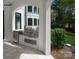 Outdoor kitchen with stainless steel grill and granite countertop, framed by an arch detail of the home's exterior at 15603 Mccullers Ct, Charlotte, NC 28277
