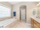 Bright bathroom with a soaking tub, tile floors, neutral colors, and arched doorways at 158 Canopy Oak Ln, Statesville, NC 28625
