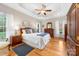Bright bedroom featuring a tray ceiling, ceiling fan, hardwood floors, and matching dark wood furniture at 158 Canopy Oak Ln, Statesville, NC 28625