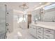 Luxury bathroom featuring double vanities, a glass-enclosed shower, and a skylight for natural light at 18038 Greyfield Gln, Fort Mill, SC 29707