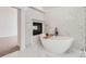 Elegant bathroom featuring a soaking tub, a fireplace, and marble-look tile at 18038 Greyfield Gln, Fort Mill, SC 29707