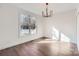 Sunlit bedroom with hardwood floors, a modern chandelier, and a large window overlooking the backyard at 18038 Greyfield Gln, Fort Mill, SC 29707