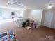 Open bonus room boasts natural light, neutral paint, and carpeted floors, perfect for a ' playroom or home office at 1814 Woods Ln, Denver, NC 28037