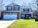 Charming two-story home featuring a brick-accented facade, attached two-car garage, and lush green lawn at 1814 Woods Ln, Denver, NC 28037