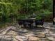 Outdoor patio features stone flooring, and outdoor dining table surrounded by lush landscaping at 1814 Woods Ln, Denver, NC 28037