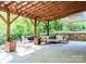 Expansive covered outdoor patio featuring a wooden frame, comfortable furniture, and views of lush greenery at 1814 Woods Ln, Denver, NC 28037