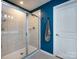 Bathroom featuring blue walls, white tile shower with glass door, and a coordinating gray towel at 2018 Sewall Sw Ave, Concord, NC 28025