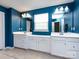 This bathroom has blue walls, tile floors, double sinks with white cabinets, and vanity lighting at 2018 Sewall Sw Ave, Concord, NC 28025