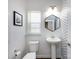 Clean bathroom with pedestal sink, white toilet, and hexagon mirror at 2018 Sewall Sw Ave, Concord, NC 28025