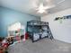 This bedroom features bunk beds, a ceiling fan, a blue accent wall, and lots of natural light at 2018 Sewall Sw Ave, Concord, NC 28025