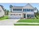 Charming two-story home featuring a two car garage, manicured lawn, and complementary green shutters at 2018 Sewall Sw Ave, Concord, NC 28025