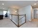 Upstairs landing with neutral carpet, white railing, and views into adjacent rooms at 2018 Sewall Sw Ave, Concord, NC 28025