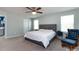 This main bedroom features a ceiling fan, a gray upholstered bed frame, and lots of natural light at 2018 Sewall Sw Ave, Concord, NC 28025