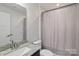 Bathroom with tile flooring, granite vanity, new lighting, toilet, and shower with curtain at 224 Parkwood Ave, Charlotte, NC 28206