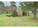 View of backyard featuring a wooden storage shed, a lush lawn, and a stone pathway at 2408 Joes Lake Rd, Shelby, NC 28152
