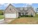 Charming home featuring a stone and vinyl exterior, attached two-car garage, and well-maintained landscaping at 2408 Joes Lake Rd, Shelby, NC 28152