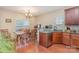 Well-lit kitchen and dining area featuring wooden floors, granite counters, stainless dishwasher, and ample cabinet space at 2408 Joes Lake Rd, Shelby, NC 28152