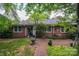 Spacious backyard featuring a brick patio, lush lawn, mature trees, and well-maintained landscaping at 2515 Sheffield Dr, Gastonia, NC 28054