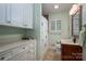 Well-lit bathroom with built-in storage, a vanity, mirror, and shower with a window at 2515 Sheffield Dr, Gastonia, NC 28054