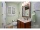 Bathroom featuring a wooden vanity, mirror, and shuttered window, with pale green walls at 2515 Sheffield Dr, Gastonia, NC 28054